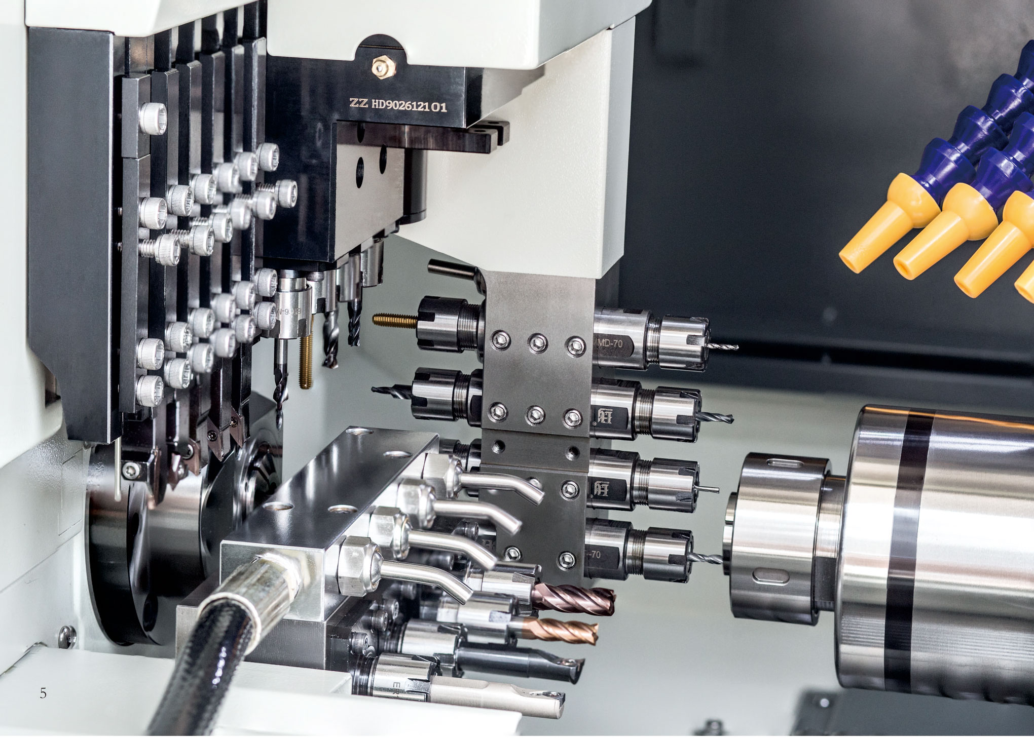 Tool zone of a Swiss-type CNC lathe with multiple live tooling stations around the guide bush and spindle